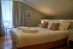 a bedroom with a large white bed with towels on it at Materramenta in Biscoitos