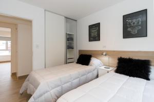2 Betten in einem Zimmer mit Spiegel in der Unterkunft Duplex Bahía Grande in Ushuaia