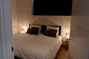 - une chambre avec un grand lit blanc et deux lampes dans l'établissement Villa Nautica Kortgene, à Kortgene