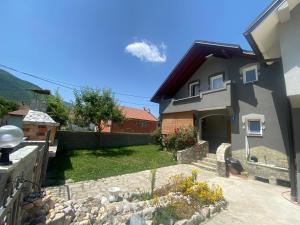 a house with a yard with a rock garden at Guesthouse GS 84326 in Gusinje