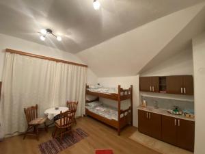 a bedroom with a bunk bed and a table and chairs at Guesthouse GS 84326 in Gusinje