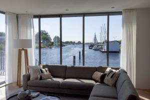 a living room with a couch in front of a large window at Villa Nautica Kortgene in Kortgene
