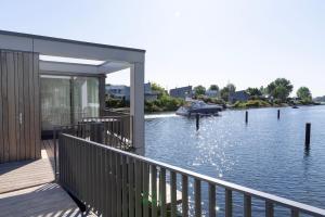 a house on a dock with a boat in the water at Villa Nautica Kortgene in Kortgene
