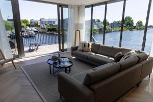 a living room with a couch and a view of the water at Villa Nautica Kortgene in Kortgene +2 photos