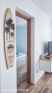 a room with a mirror and a surfboard on the wall at Cozy apartment with wonderful view - Los Cristianos in Arona