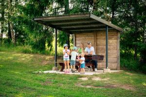 a family standing in front of a picnic shelter at Uhtjärve Ürgoru Nõiariik in Antsla