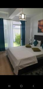 a bedroom with a large bed and a window at Body Residence in Mamaia Nord