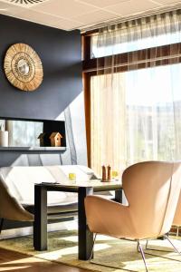 ein Esszimmer mit einem Tisch, Stühlen und einem Fenster in der Unterkunft Novotel Paris Créteil Le Lac in Créteil