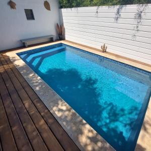 a large swimming pool with a wooden deck at La Cas'Aline in La Saline les Bains