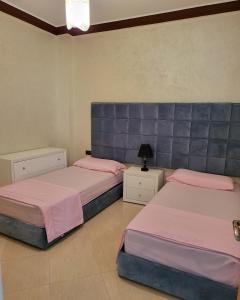 2 Betten in einem Schlafzimmer mit rosa und lila in der Unterkunft Résidence De Luxe AL Manzah in Al Hoceïma