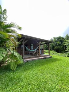 a house with a hammock in a yard at Bungalow à flanc de colline in Le Morne Rouge