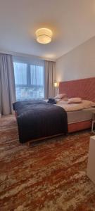 Un dormitorio con una cama grande y una ventana grande. en Bel Mare Invest - free parking, en Międzyzdroje