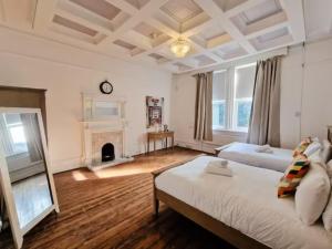a large bedroom with two beds and a fireplace at Sleeps 20 Stunning Ashton Mansion in Ashton under Lyne