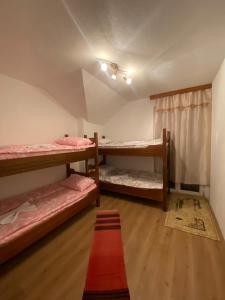 a room with two bunk beds and a red rug at Guesthouse GS 84326 in Gusinje