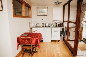 a kitchen with a table with a red table cloth on it at The Barn B&B in Margam