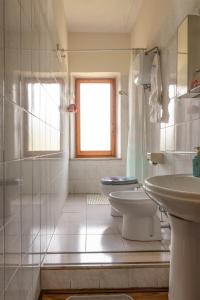 a white bathroom with a toilet and a sink at B&B Locanda Sant'Antimo in Montalcino