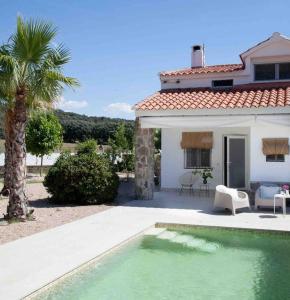una casa con piscina di fronte a una casa di Venta Viñas, finca privada en la naturaleza, con piscina a Mejorada