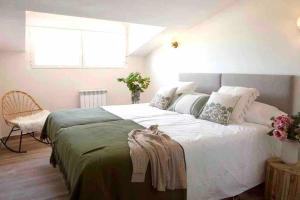 una camera da letto con un grande letto bianco e una sedia di Venta Viñas, finca privada en la naturaleza, con piscina a Mejorada Altre 18 foto