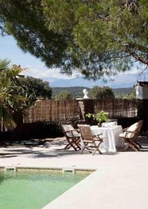 patio ze stołem i krzesłami przy basenie w obiekcie Finca Venta Viñas, piscina privada. Toledo. Nueva. w mieście Mejorada