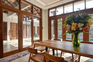 マスジッド・タナにあるElshape Holiday VILLAの花瓶付きのテーブルのあるダイニングルーム +11枚の写真