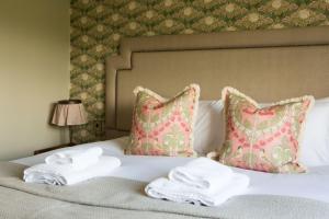 Una cama con toallas y almohadas. en Alvanley Arms, Cotebrook, en Tarporley