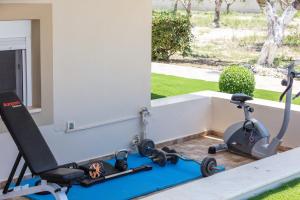 a gym with a treadmill and a exercise bike at Villa Daphne in Pangalochori +61 photos