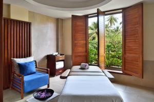 本托塔的住宿－Sheraton Kosgoda Turtle Beach Resort，一间卧室配有两张床和一张蓝色椅子