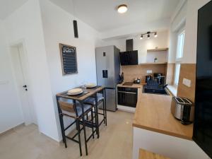 een keuken met een aanrecht en barkrukken bij Studio apartment SeaDream - 50 meters from the sea in Brodarica