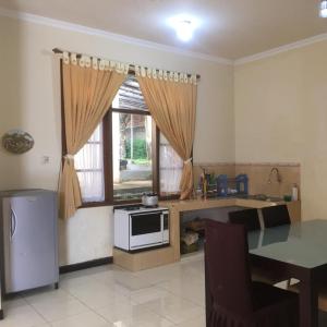 a kitchen with a table and a microwave and a window at Villa Bukit Punclut in Bandung