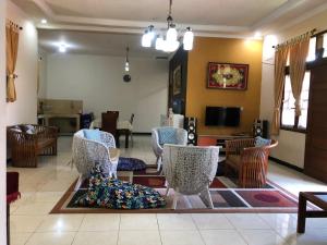 a living room with chairs and a table and a television at Villa Bukit Punclut in Bandung