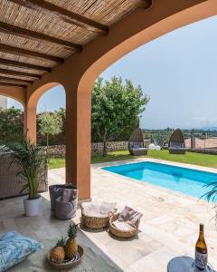 a villa with a swimming pool and a patio at Villa Sarri by Sarris Winery in Metaxáta
