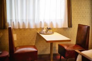 a table and two chairs in a room with a window at COFFEE HOTEL Soundwave in Fujisawa