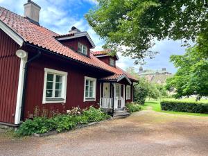 una casa roja con techo rojo en Engsholms Slott - Adults Only, en Mörkö
