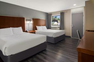 um quarto de hotel com duas camas e uma televisão em Canadas Best Value Inn & Suites Kamloops em Kamloops