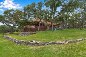 a house with a stone wall in front of a yard at Rocky Mountain in New Braunfels