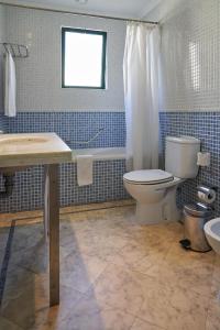 a bathroom with a toilet and a sink and a tub at The Navigator - Palm Oasis Alvor - All Inclusive in Alvor