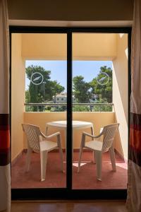 a table and two chairs sitting on a balcony at The Navigator - Palm Oasis Alvor - All Inclusive in Alvor