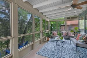 a screened in porch with windows and a ceiling fan at Lily Pad in Wimberley