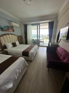 een hotelkamer met twee bedden en een bank bij Ceti̇n Presti̇ge Resort in Erdek +45 foto's