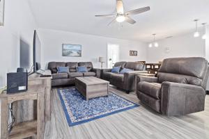 a living room with leather furniture and a flat screen tv at Nature's Coast Retreat in Spring Hill
