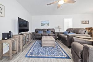 a living room with a couch and a tv at Nature's Coast Retreat in Spring Hill +42 photos
