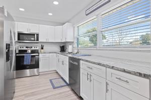 a kitchen with white cabinets and stainless steel appliances at Nature's Coast Retreat in Spring Hill