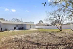 a white house with a fence and a yard at Nature's Coast Retreat in Spring Hill