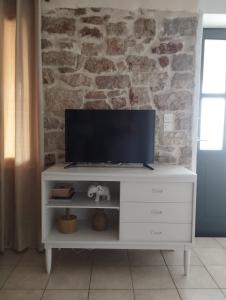 a white entertainment center with a flat screen tv on it at Το Πέτρινο in Aitolikón