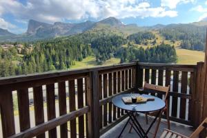 una mesa en un balcón con vistas a las montañas en Appartement 10 personnes au pied des pistes - Superdévoluy, en Superdevoluy