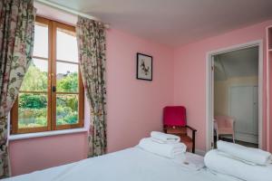 1 dormitorio con 2 camas y ventana en La Ruche Chambres d'hôtes, en Ségur-le-Château