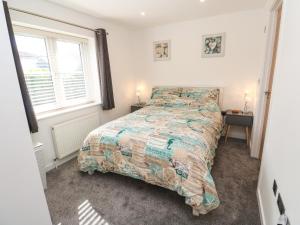 1 dormitorio con 1 cama con un edredón colorido en 20 The Walled Garden en Penryn
