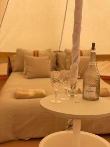 einen Tisch mit einer Flasche Wein und Gläsern auf einer Couch in der Unterkunft Wheeldon Escapes in Totnes