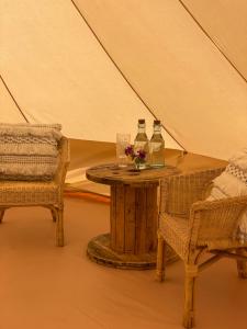Pokój ze stołem oraz 2 butelkami i krzesłami w obiekcie Wheeldon Escapes w mieście Totnes