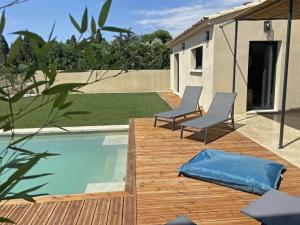 une terrasse avec deux chaises et une piscine dans l'établissement Le nid d'Emilie, à Maillane